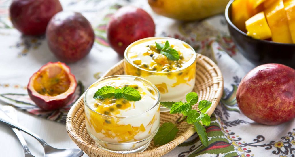 Passion fruit mango-mint lassi on glass with the fruits